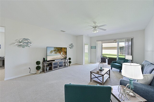 living area with carpet, visible vents, ceiling fan, and baseboards