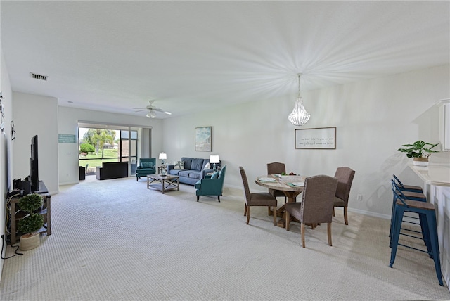 dining space featuring visible vents, ceiling fan, light carpet, and baseboards