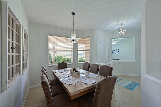 dining room featuring an inviting chandelier, light tile patterned floors, and baseboards