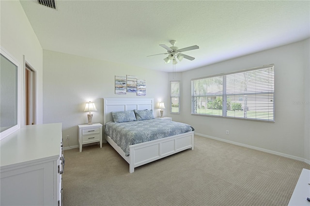 bedroom with light carpet, baseboards, visible vents, and a ceiling fan