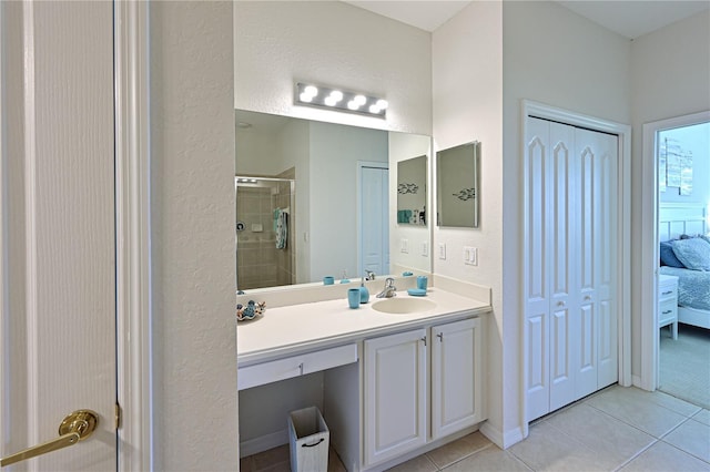 full bath featuring baseboards, ensuite bath, tile patterned flooring, vanity, and a shower stall