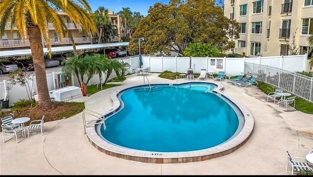 pool with a patio area and fence