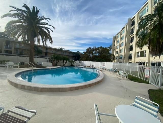 community pool featuring a patio area and fence