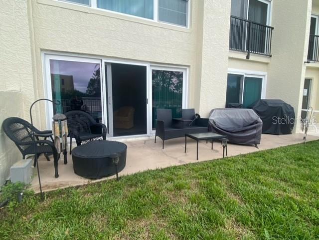 back of property featuring a patio area, a yard, and stucco siding