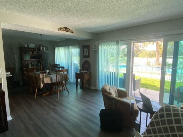 dining area featuring a wealth of natural light, a textured ceiling, and wood finished floors