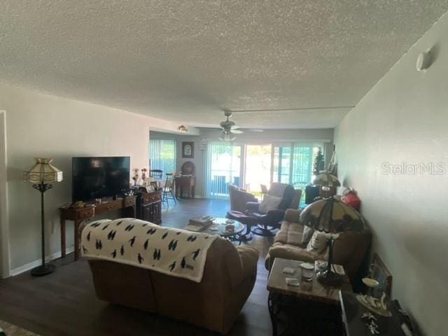 living area featuring a textured ceiling, a ceiling fan, and wood finished floors