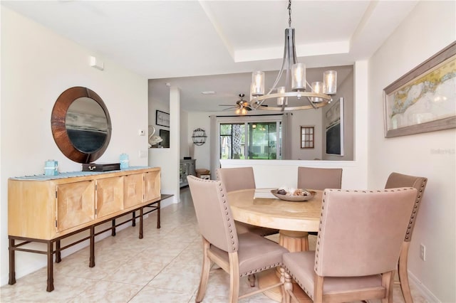 dining room featuring a raised ceiling, light tile patterned flooring, and a chandelier