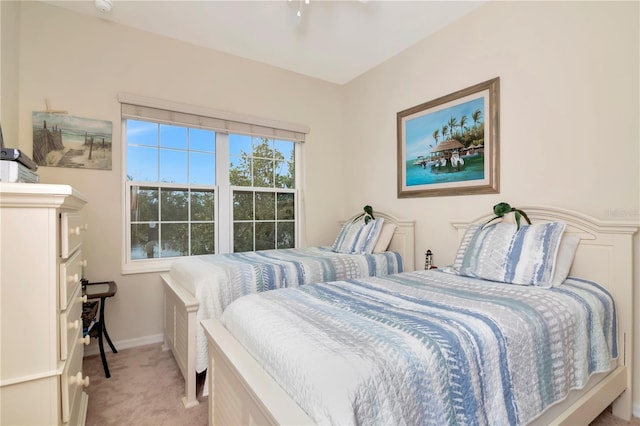 bedroom with a ceiling fan, light colored carpet, and baseboards