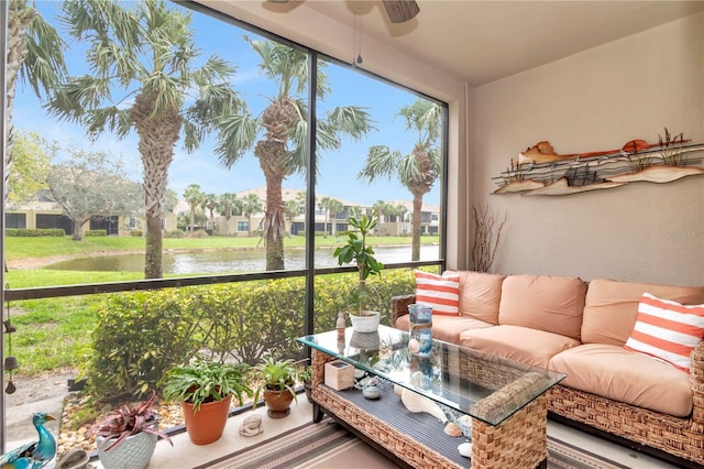 sunroom featuring a ceiling fan, a water view, and a residential view