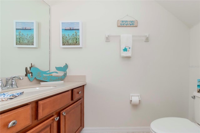 bathroom featuring baseboards, toilet, and vanity