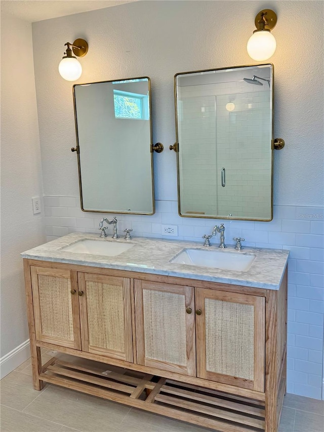 bathroom featuring double vanity, a sink, tile walls, and a shower stall