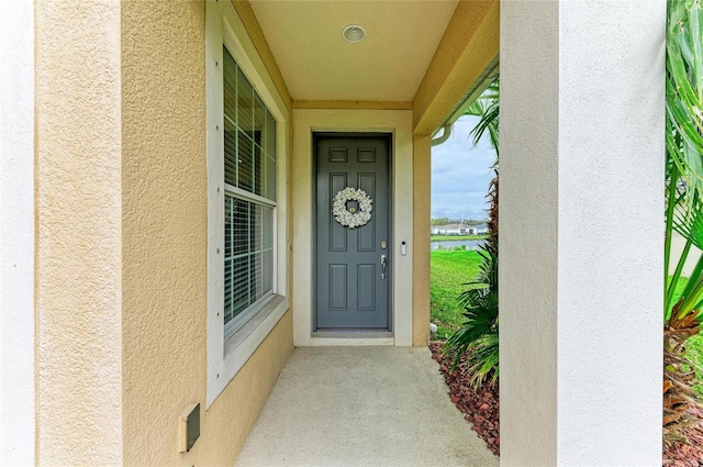 doorway to property featuring stucco siding