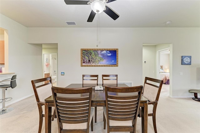 dining area featuring light colored carpet, visible vents, ceiling fan, and baseboards