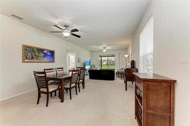 dining space with light carpet, ceiling fan, visible vents, and baseboards