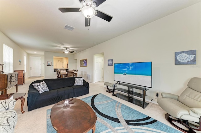 living room with visible vents, a ceiling fan, and light colored carpet