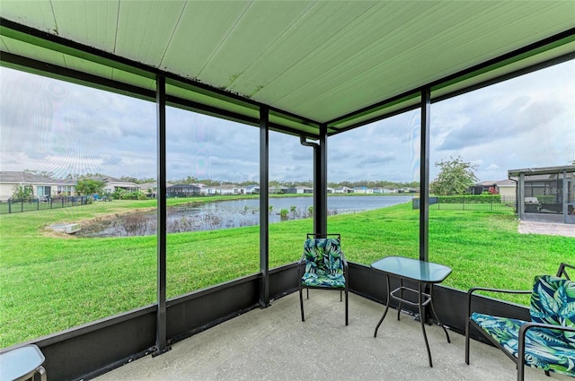 sunroom / solarium featuring a water view