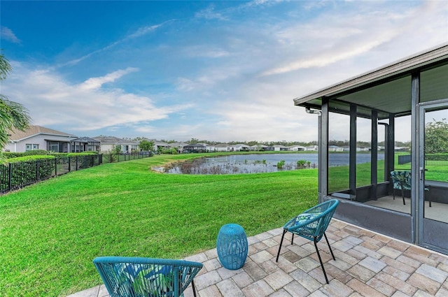 view of yard featuring a water view, fence, and a patio