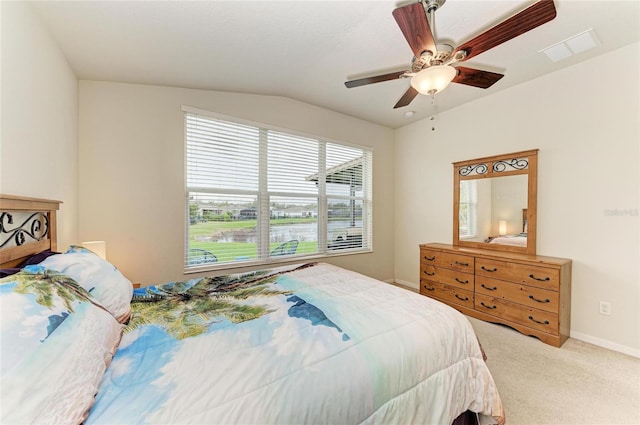 carpeted bedroom with baseboards, visible vents, vaulted ceiling, and a ceiling fan