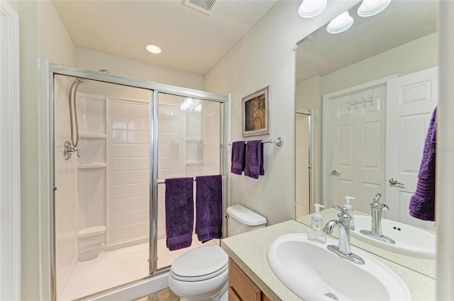 bathroom featuring visible vents, vanity, a shower stall, and toilet