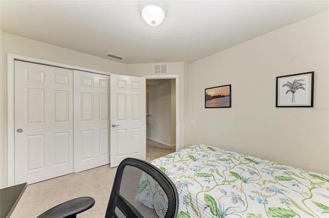 bedroom featuring a closet, light colored carpet, and visible vents