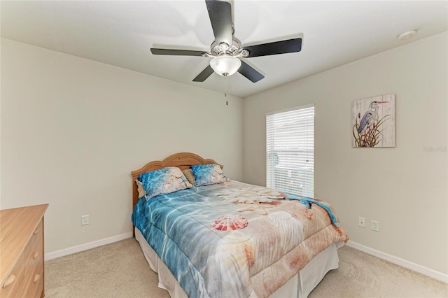 carpeted bedroom featuring baseboards and a ceiling fan