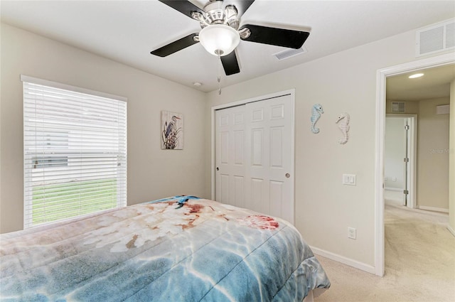 bedroom featuring light carpet, a closet, visible vents, and baseboards