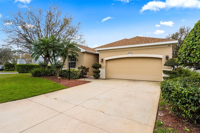 view of front of house featuring stucco siding, a shingled roof, a garage, driveway, and a front lawn