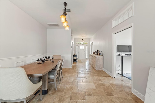 dining area featuring baseboards, visible vents, and stone tile floors