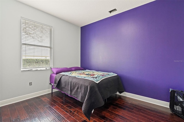 bedroom featuring baseboards, visible vents, and hardwood / wood-style floors