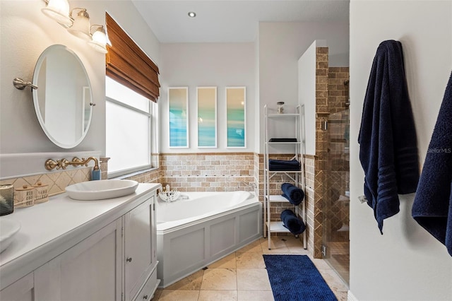 full bath featuring a garden tub, tile patterned flooring, a sink, tile walls, and tiled shower