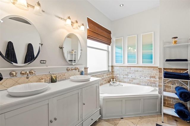 bathroom featuring a garden tub, double vanity, and a sink