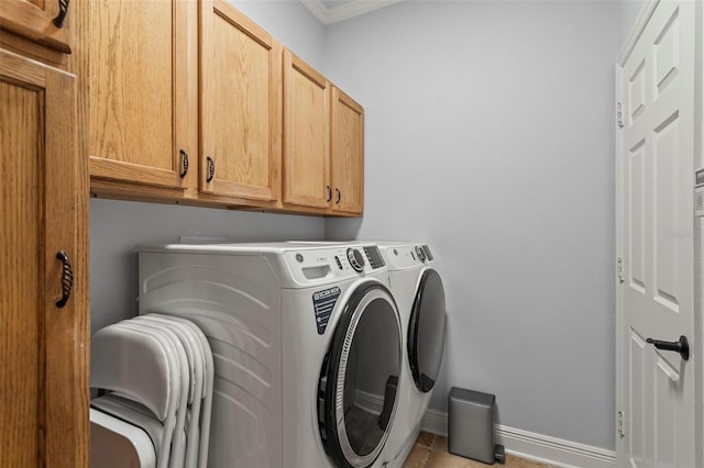 washroom with washing machine and dryer, cabinet space, and baseboards