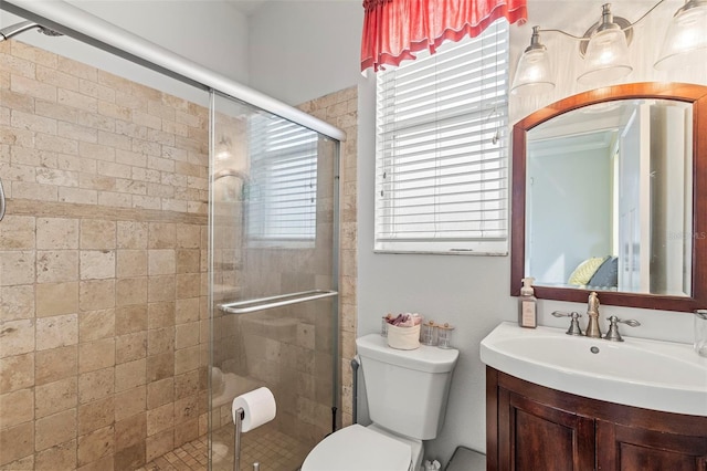 bathroom featuring a stall shower, a healthy amount of sunlight, vanity, and toilet