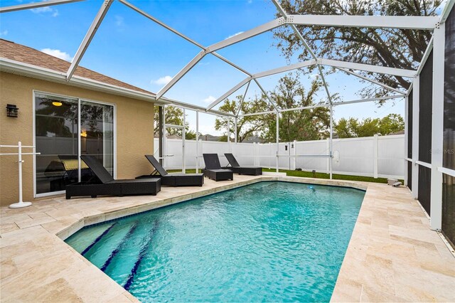 view of pool with fence private yard, a patio area, glass enclosure, and a fenced in pool