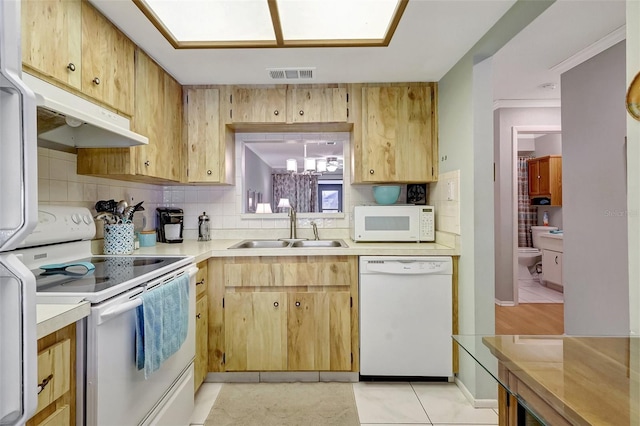 kitchen featuring light countertops, visible vents, a sink, white appliances, and under cabinet range hood