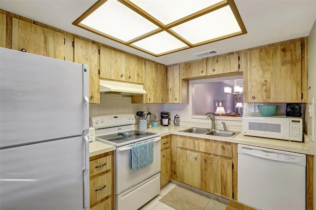 kitchen featuring under cabinet range hood, white appliances, a sink, visible vents, and decorative backsplash