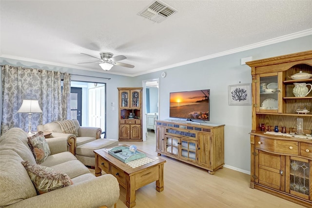 living area featuring ceiling fan, ornamental molding, visible vents, and light wood-style floors