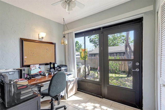 office space with light tile patterned floors, plenty of natural light, a textured ceiling, and a textured wall