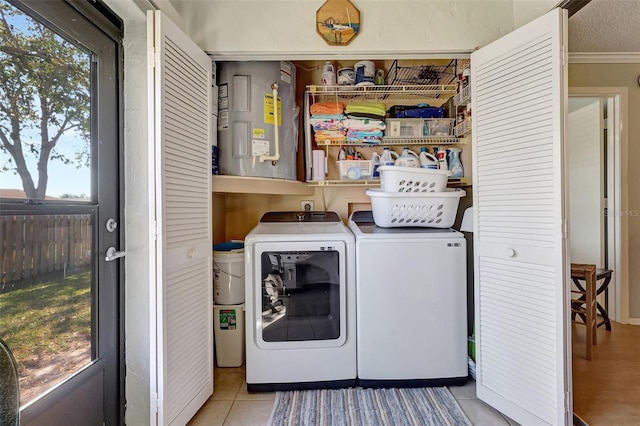 washroom featuring a wealth of natural light, laundry area, washing machine and clothes dryer, and light tile patterned floors