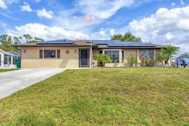 single story home with a front yard, solar panels, and stucco siding