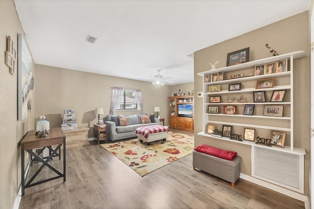 sitting room featuring a ceiling fan, visible vents, and wood finished floors