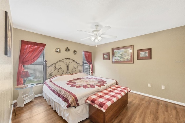 bedroom featuring ceiling fan, baseboards, and wood finished floors