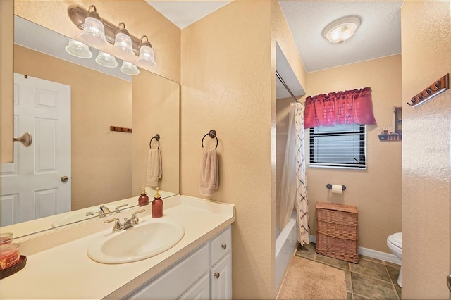 bathroom featuring toilet, vanity, baseboards, tile patterned floors, and shower / bath combo with shower curtain