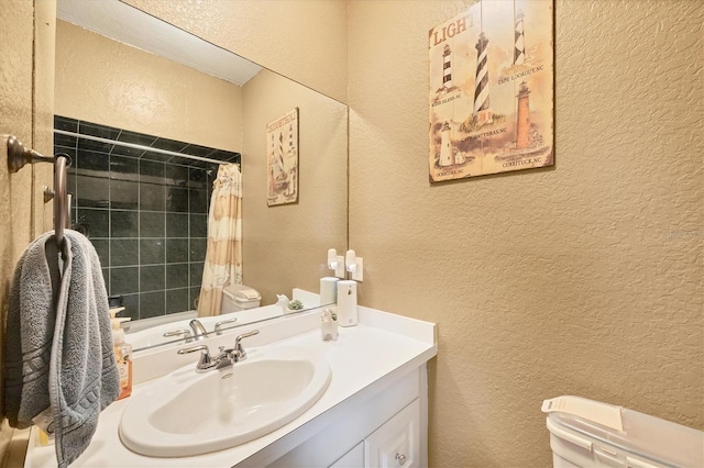 full bath featuring a shower with shower curtain, a textured wall, vanity, and toilet