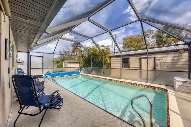 view of pool with glass enclosure, a patio area, and a covered pool