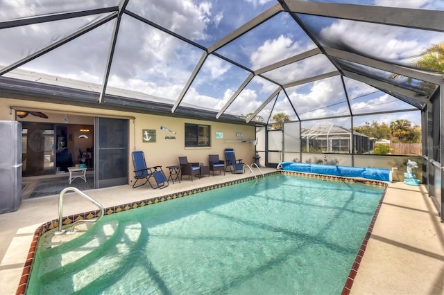 view of swimming pool featuring a covered pool and a patio