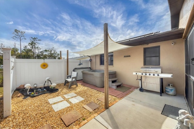 view of patio / terrace with fence private yard, a hot tub, and area for grilling