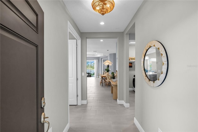 hall featuring recessed lighting and baseboards