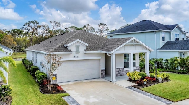 view of front of house featuring stucco siding, a shingled roof, a front lawn, concrete driveway, and a garage