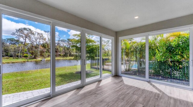 unfurnished sunroom featuring a water view